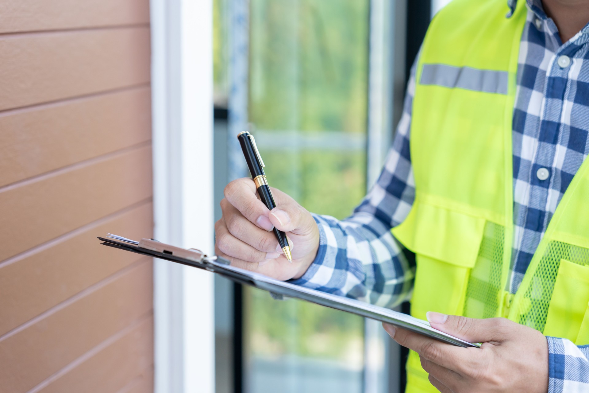 inspector or engineer is inspecting construction and quality assurance new house using a checklist. Engineers or architects or contactor work to build the house before handing it over to the homeowner